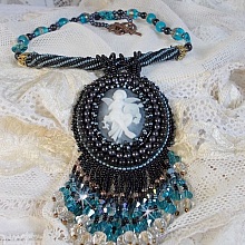 Pendentif Angelot avec un cabochon Ange brod&eacute; de perles rondes nacr&eacute;es Cristal avec des rocailles. S&rsquo;ajoute des facettes, toupies, perles ovales Lampwok serti d&rsquo;un ruban Dor&eacute; et palets